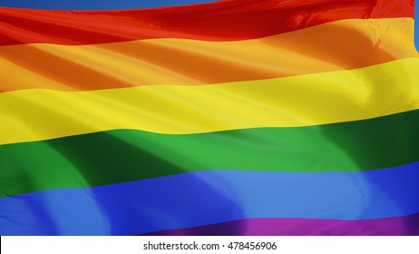 The Gay Pride Rainbow Flag Waving Against Clean Blue Sky, Close Up, Isolated With Clipping Path Mask Alpha Channel Transparency