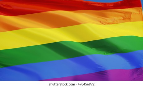 The Gay Pride Rainbow Flag Waving Against Clean Blue Sky, Close Up, Isolated With Clipping Path Mask Alpha Channel Transparency