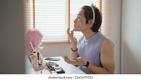 Gay queer man non-binary beauty blogger makeup artist at home cross dressing up apply face skin care eye make up brush. Real asia LGBT young guy adult people happy relax smile looking at mirror pride. - Powered by Shutterstock