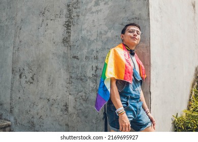 Gay Teen Man With Lgbt Flag On Gray City Wall In Sunny Day