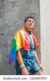 Gay Teen Man With Lgbt Flag On Gray City Wall In Sunny Day