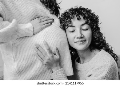 Gay women pregnancy - Lesbian pregnant couple having tender moment listening baby belly - Focus on right female - Black and white edition