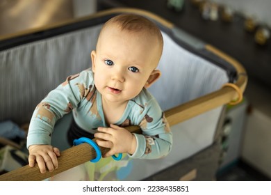 The gaze of an inquisitive child clinging to the crib