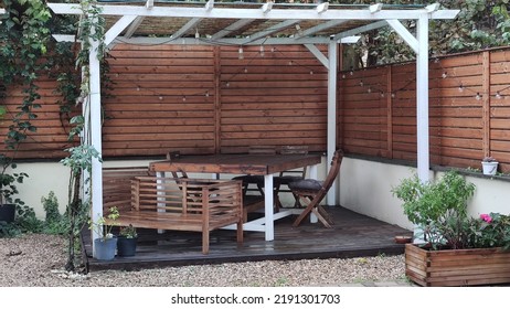 Gazebo With Lights At Night. Picture Of A Summer House With Comfortable Garden Furniture. Romantic Scene In Dusk