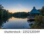 A gazebo looks out over the calm waters of Mill Pond in Milton during the late sunset.