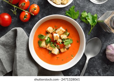 Gazpacho soup in bowl over dark stone background. Cold tomato soup. Healthy food concept. Top view, flat lay