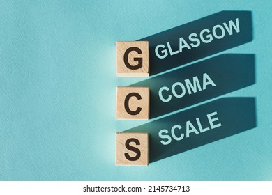 GCS Glasgow Coma Scale Text, Written On Wooden Blocks With Shadows On Blue Background.