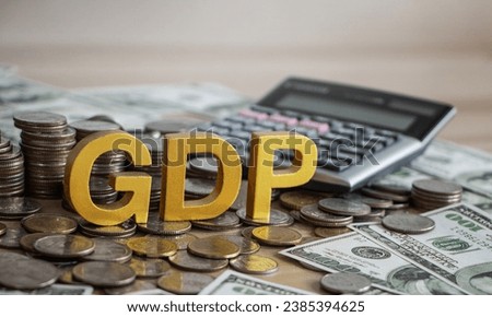 GDP, Gross domestic product concept. Gold gdp text and Coins stack with calculator on a beautiful background from dollar bills. Business and GDP, good distribution practice. Copy space. [[stock_photo]] © 