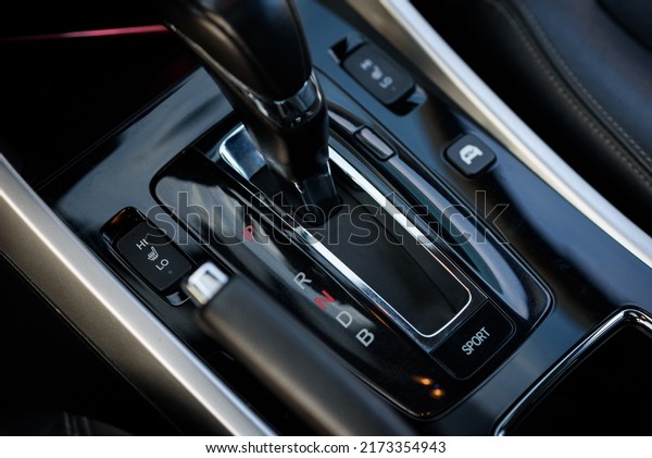 Gear shift stick into P position, (parking)\
symbol in automatic transmission car. Modern automatic gearbox\
hybrid car. Close up of the gear box transmission handle. Car\
detailing. Interior car\
inside.