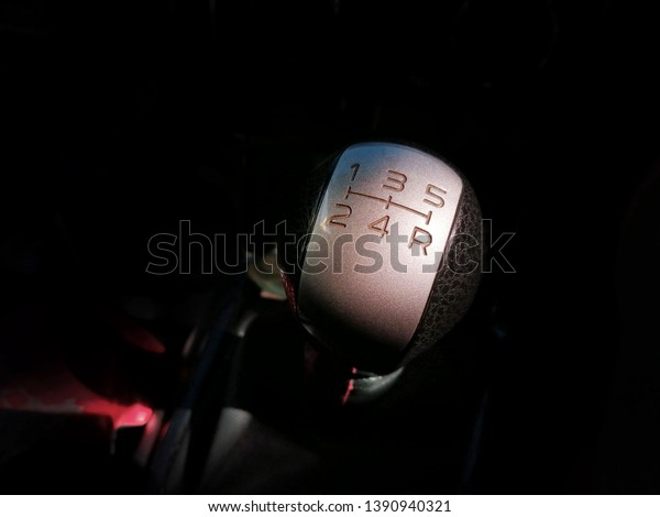 Gear stick of manual\
transmission of car with 5-speed and reverse position, automotive\
part concept.