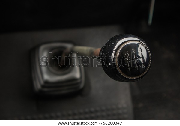 A gear stick of an old van. Visible knob,\
stick and rubber boot on the\
floor.