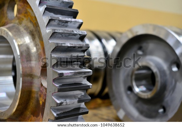 Gear wheel, gear after\
machining on lathe and CNC milling machine lies on a wooden rack in\
the shop.