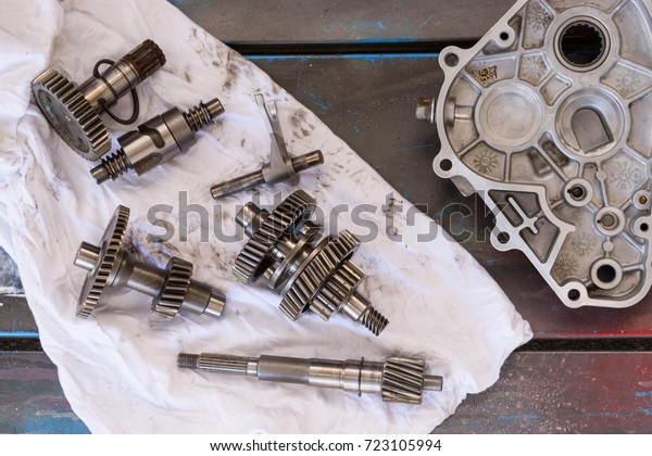 Gearbox parts on a\
old wooden table with\
tools
