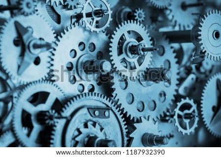 Gears and cogs macro in vintage old mechanism blue toned