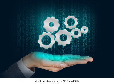 Gears mechanism floats on the human hand over digital background - Powered by Shutterstock - Get 15% off with code: PIKWIZARD15