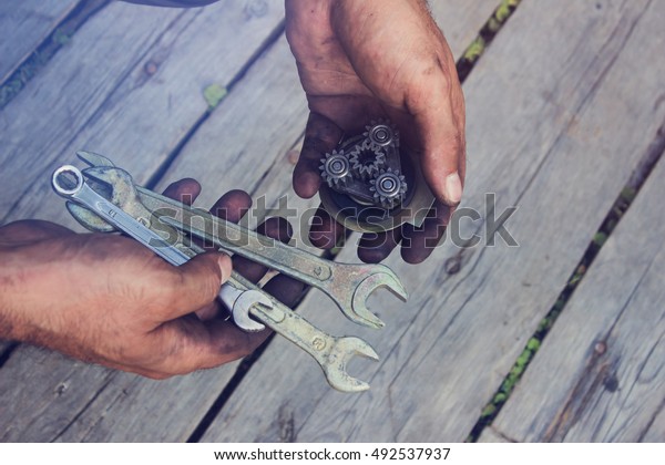 Gears\
and wrenches close-up in the hands of the\
locksmith