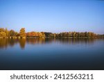 The Gebarti lake with line of autumn trees in the background in Zalaegerszeg, Hungary