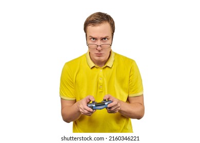 Geek gamer nerd in glasses and yellow T-shirt with gamepad isolated on white background. Young adult nerd guy holding joystick and playing videogames on TV, excited video game player