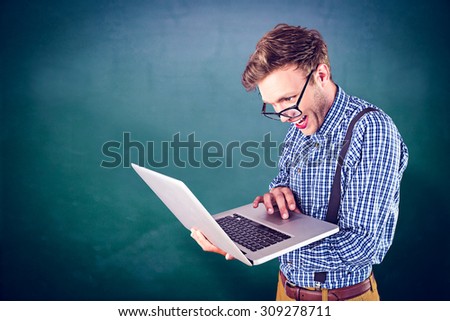 Geeky businessman using his laptop against green chalkboard