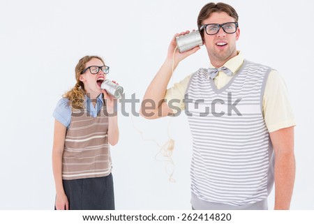 Geeky hipster couple speaking with tin can phone on white background