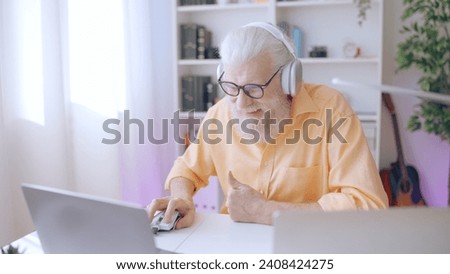 A geeky senior man indulges in his passion for gaming, enjoying his leisure time with his favorite hobby