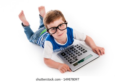 Geeky toddler boy lying on the floor with big calculator and big geeky glasses. Studio shot isolated on white.