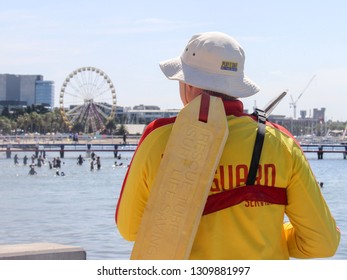 GEELONG, VICTORIA - JANUARY 26 2018 A Male Lifeguard Watches Over A Busy Eastern Beach During The Australia Day Long Weekend