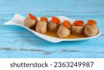 Gefilte fish served with carrot pieces on fish shaped plate for Jewish holiday Rosh Hashanah, Pesach.