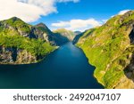 Geiranger Fjord, Norway. Nature in fjords. Traveling by boat on a Norwegian fjord. Scandinavia. View of nature from the drone. Seven Sisters Waterfall. Vacation and travel in summer Norway.