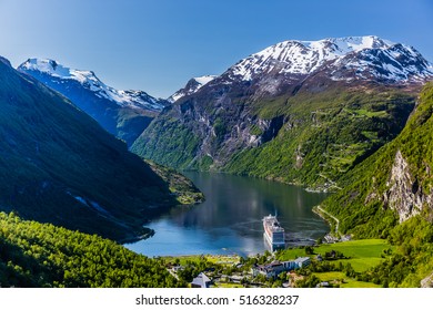 Geirangerfjord With A Ship In A Port From Above, With Mountain Peaks Covered With Snow