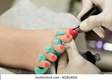 Gel Pedicure. Pink Color On The Nails And White Gloves Of Master