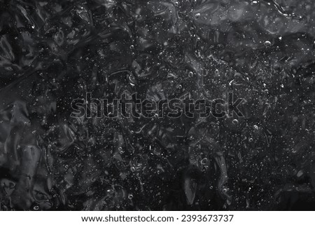 gel structure on black  background, backdrop for cosmetic products, soft focus close up 