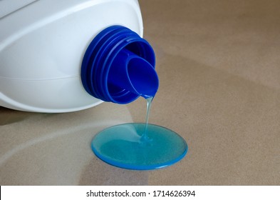 Gel for washing clothes is poured. White plastic canister with washing gel dropped. Homemade routine. Household chemicals. Selective focus. - Powered by Shutterstock