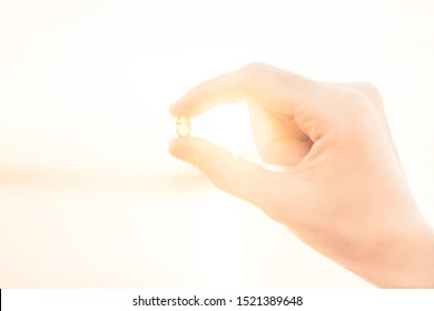 Gelatin Capsule With Vitamin D In Female Hands In The Sun. Vitamin D Deficiency Concept