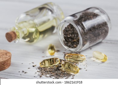 Gelatin Capsules With Algae Omega Oil And Seaweed On White Wooden Background. Dietary Supplements. Close Up