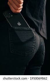 Gelendzhik, Russia, 24 March 2021: The woman get out an iPhone 11 out of his pocket. Close-up of the Apple logo and a phone camera.