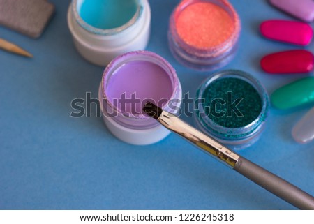 Gel-paint for nail design and brush. Set of cosmetic tools for manicure and pedicure on a blue background. Manicure - creation tools, UV lamps, beauty, care concept.