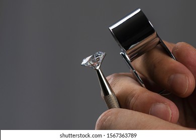 Gem stones. Jeweller checking polished diamond. Carat size diamonds. Diamond trading and dealing. Loose diamond grading. Precious stones.