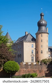 Gemen castle with its characteristic onion dome tower, standing tall against a clear blue sky, exudes historical grandeur