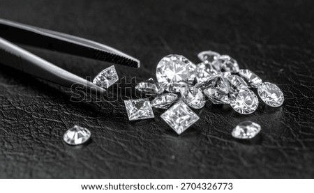Gemologist Dropping Solitaire Diamond on the Black Texture Diamond Tray along with other Diamonds 