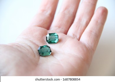 Gemstone green color Sapphire Tourmaline on woman hand on white background with selective focused