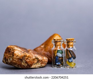 A Gemstone And A Tiny Glass Container Isolated On A Grey Background