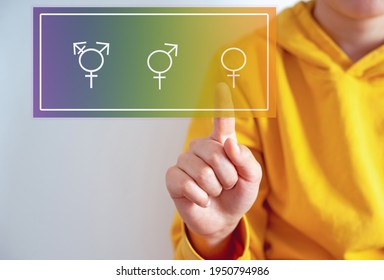 Gender Confusion In Teenager.  A Teen Boy Pointing At Gender Symbols Of Male Bigender And Transgender. Concept Of Choice Gender Confusion Or Dysphoria.