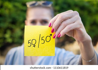 Gender Equality Concept, A Piece Of Paper With A Female And A Male Symbol In A Woman's Hand