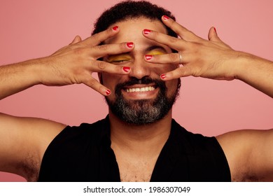 Gender fluid male showing his makeup and smiling. Happy man wearing nail polish and eye makeup.