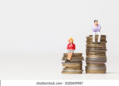 Gender Pay Equality Concept. Man And Woman On A Stack Of Coins.