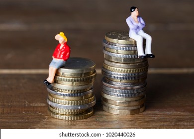 Gender Pay Equality Concept. Man And Woman On A Stack Of Coins.