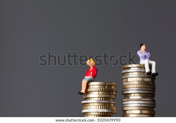 Gender pay equality concept. man and woman on a\
stack of coins.