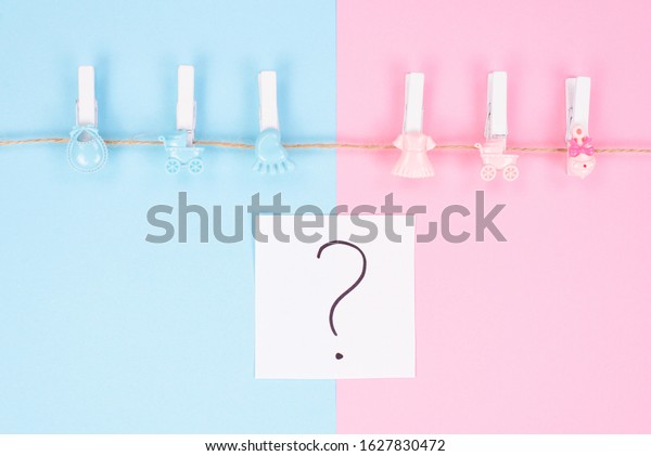 Gender reveal party\
invitation concept. Background photography of small pegs with\
carriage toys isolated on divided into two parts background\
question mark in center