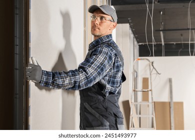 General Contractor Installing Drywall Panel in a Newly Restored Room
